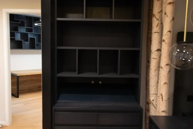 Dunkler Schrank mit offenen Regalfächern