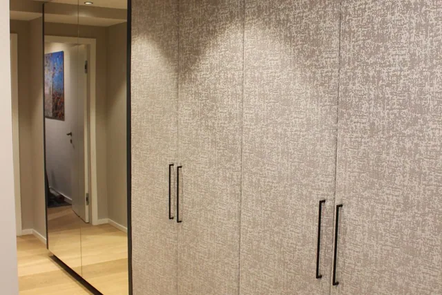 Heller Einbauschrank mit dunklen Griffen